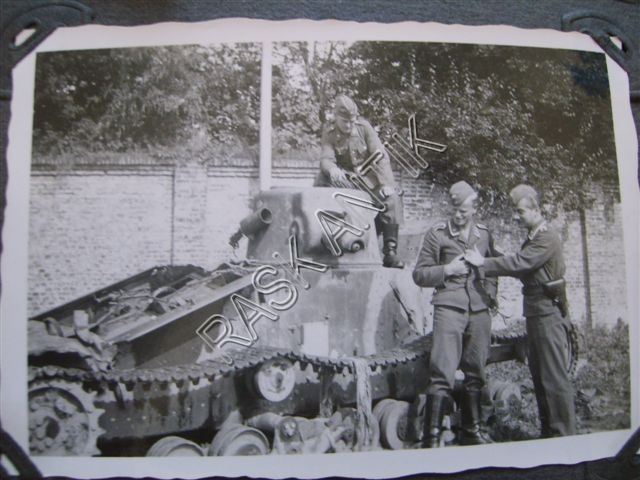 Photograph of Luftwaffe men standing beside a damaged tank